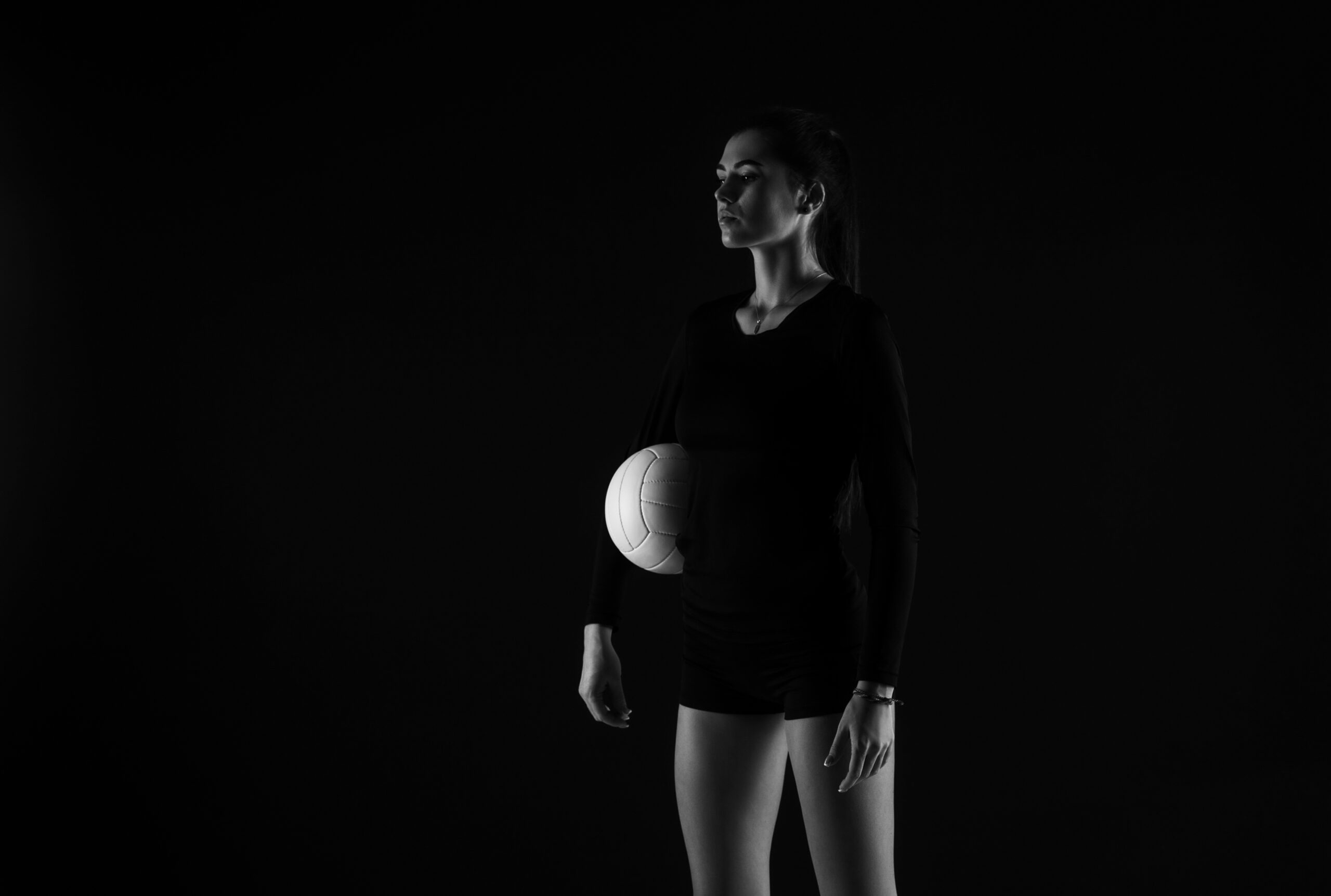Volleyball girl hold ball on dark background. Player doing sport workout online. Sport and recreation concept. Black and white color filter